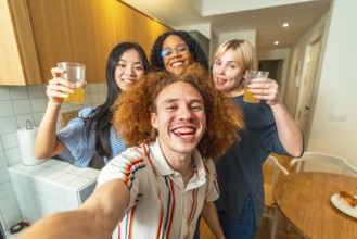 Group of cheerful multi ethnic friends taking a selfie while drinking juice, celebrating and having