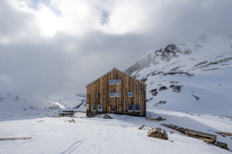 Chamanna Es-cha mountain hut in a cloudy winter mountain landscape, Bündner Haute Route ski tour,