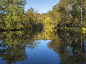 Trees reflected in the river Saale in the Saale valley not far from the Dornburg castles,