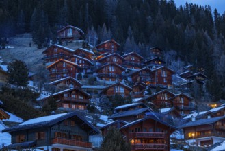 Chalets built into the hillside as holiday homes at dusk, Grimentz, Val d'Anniviers, Valais Alps,