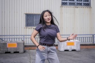 Female asian young artist dancing K-pop korean dance alone in the city