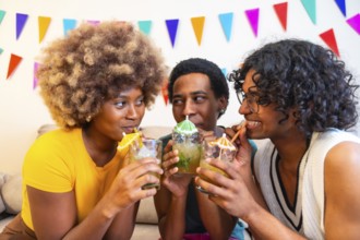 Cool multi-ethnic friends enjoying cocktails drinking sucking with straw and partying at home