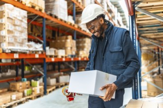 Happy african man worker preparing parcels to deliver in a warehouse