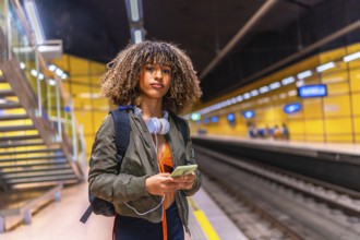 Beauty woman with curly hair and brunette skin using phone while waiting the underground metro