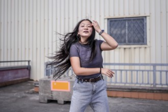 Beauty asian woman dancing modern urban k-pop dance energetically in the city