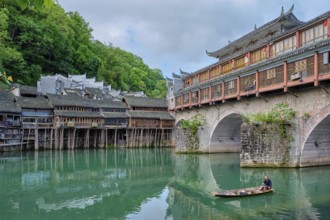 FENGHUANG, CHINA, APRIL 23, 2018: Unidentified chinese man in boat Feng Huang Ancient Town (Phoenix