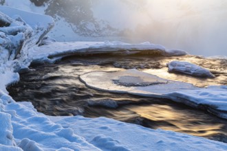 The morning sun reflected in the river Skjalfandafljot, snow-covered landscape, Northern Iceland