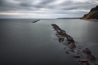 Coastal protection made of boulders, coastline on the Baltic Sea, dusk, long exposure, Baltic Sea