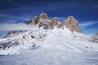 View of a ski resort piste with people skiing in Dolomites in Italy