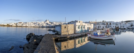 Panorama, view of the town of Naoussa and blue sea, harbour with fishing boats and reflection,