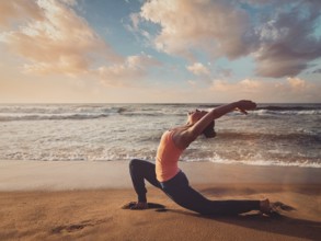 Vintage retro effect filtered hipster style image of Yoga outdoors, sporty fit woman practices yoga