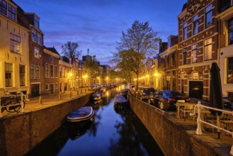 Typical Netherlands city view, canal with boats and houses illuminated in the evening. Haarlem,