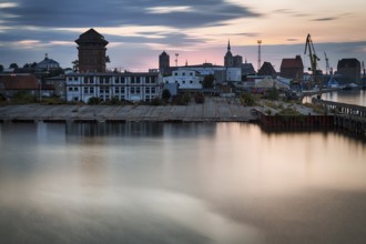 Harbour buildings, construction cranes and church towers, skyline at dusk, long exposure, Stralsund