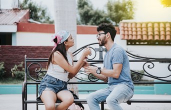 Young couple arguing sitting on a park bench, Concept of aggressive couples in the park. Upset