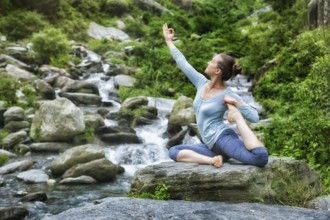 Young sporty fit woman doing yoga asana Eka pada rajakapotasana, one-legged king pigeon pose at