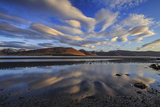 Ebb pond at a fjord off Bergen, evening light, clouds reflected in the water, Westfjords, Iceland,