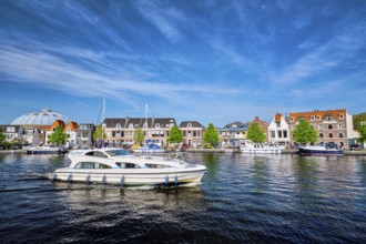 HAARLEM, NETHERLANDS, MAY 6, 2017: Boats and houses on Spaarne river with blue sky. Haarlem,