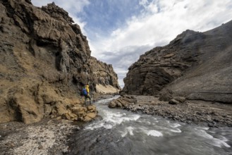 Hikers by the river, Drekagil, gorge in the crater rim of Askja volcano, Dyngjufjöll mountain