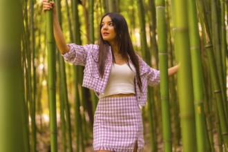 Young caucasian girl with a pink skirt in a bamboo forest. Enjoying the city on summer holidays in