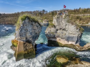 Aerial view of the Rhine Falls at low water in spring, with tourists on the viewing platform, in