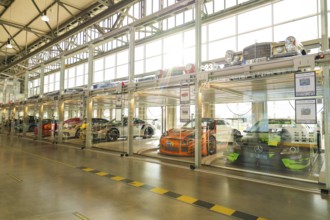 Cars in a two-storey glass garage with natural daylight and minimalist design, Motorworld
