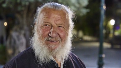 Papas Vaianos, Pope in Psinthos, An elderly man with a white beard smiles outdoors at night, Easter