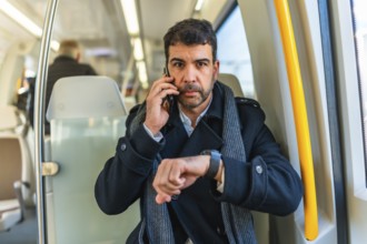Frontal portrait of a serious caucasian adult, businessman using smartwatch while talking to the