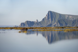 View of coastal landscape with reflection, steep coast with peak Måtind, Andøya island, Vesterålen,