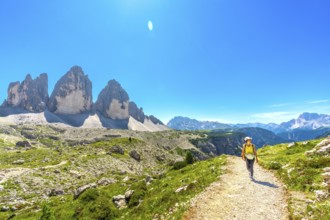 Tourist walking on a mountain path near tre cime di lavaredo, a symbol of the dolomites, a unesco
