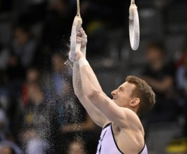 Nils Dunkel GER prepares rings with magnesia Gymnastics, EnBW DTB-Pokal, Porsche-Arena, Stuttgart,