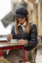 Tourist savoring a cappuccino at an outdoor cafe in bordeaux, france, enjoying the charming