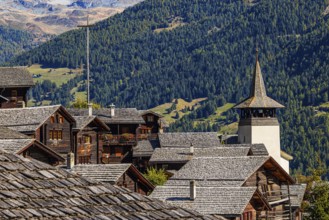 Old wooden houses and the Saint Theodule church in the historic village centre, Grimentz, Val