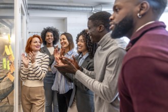 Diverse colleagues applauding at the end of creative brainstorming process in a coworking space