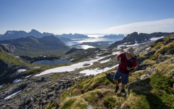View of mountains and fjord landscape, mountaineers at the summit of Rundfjellet, Austenesfjord and