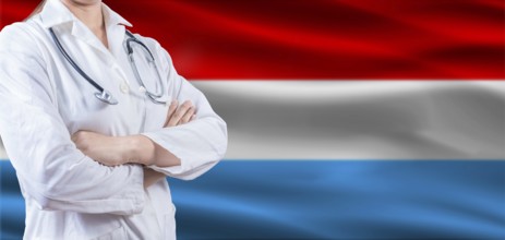 Doctor with crossed arms on Luxembourg flag. Luxembourg health and care concept. Female doctor on