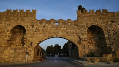 Arsenal Gate, Statdtamuer Rhodos, Medieval city gate made of stone with evening lighting, harbour