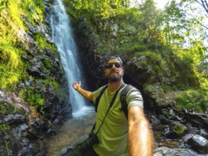 Man tourist hiker in summer at Todtnau waterfall in Black Forest in Germany