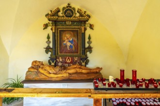 Reclining wooden statue of jesus christ and painting of madonna with child inside the santa