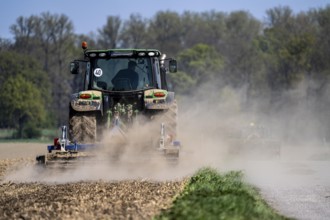 A tractor works a field, due to long dryness in spring, no rain for more than 4 weeks, the fields
