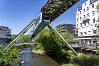 The Wuppertal suspension railway, train of the latest generation 15, floats above the Wupper, North