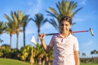 Horizontal close-up portrait of a girl with golf club on shoulder
