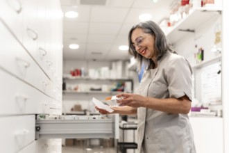 Woman pharmacist searching medicines in the storage room of the pharmacy store
