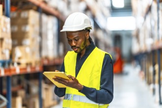 An african male warehouse worker taking inventory in the storage room