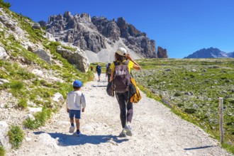 Tourists walking on a sunny summer day on the trail around tre cime di lavaredo in the dolomites