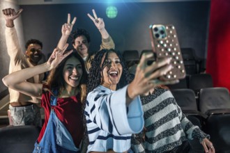 Young people taking a selfie at the movie theater during a disco dance event, having fun and
