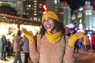 Young woman wearing yellow winter clothes expressing joy at christmas market in manezhnaya square,