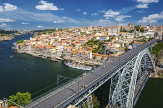 View of Porto city and Douro river with moored sailing ship and Dom Luis bridge I from famous