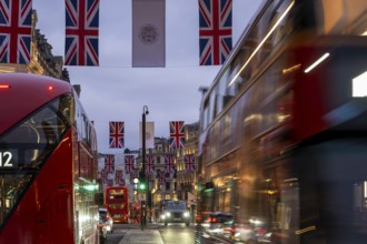 Red double-decker buses, English flags, evening mood, Oxford Circus, London, London region,