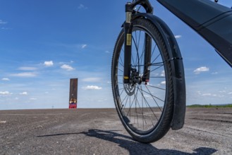 Cycling in the Ruhr area, on the Schurenbach slag heap, Bramme landmark for the Ruhr area by artist