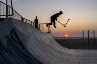 Skater, scooter in a halfpipe at the beach of Scheveningen, sunset, Netherlands